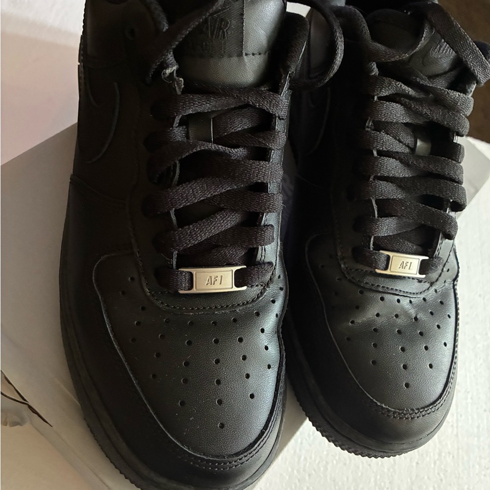 Nike Black Air Force 1 with Leather Upper and Perforated Toe.